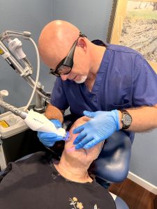 Dr. Joerg Schuller performing Secret PRO microneedling on woman's face