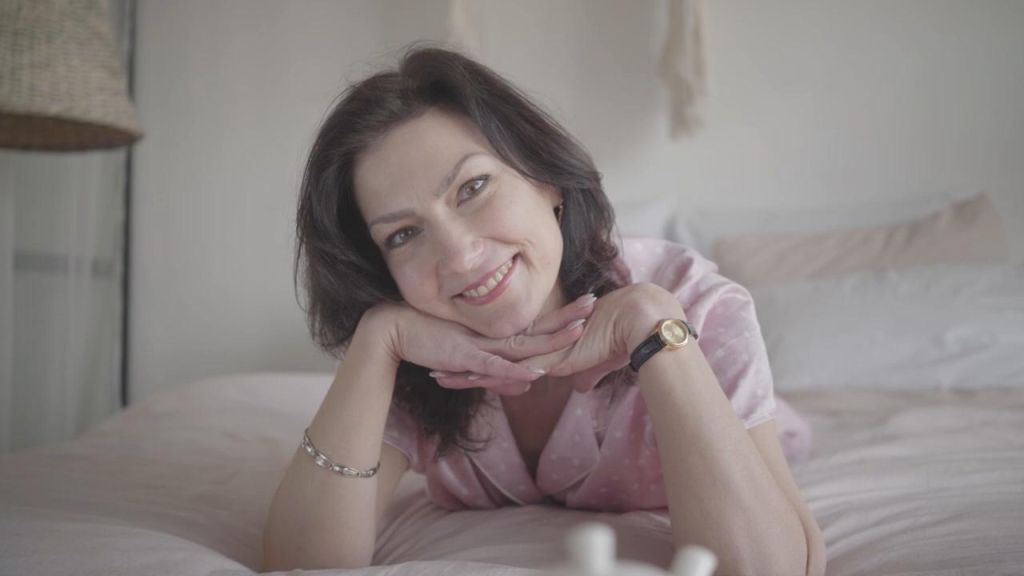 Woman smiling with her head resting on her hands