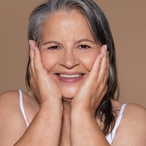 Smiling woman holding her face with both hands