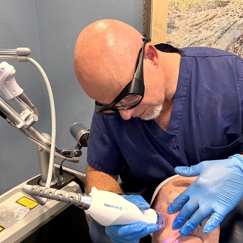 Dr. Joerg Schuller performing an aesthetic medicine procedure in his office