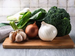 Onions-Garlic-Broccoli Onions, garlic, broccoli and bok choy on a cutting board