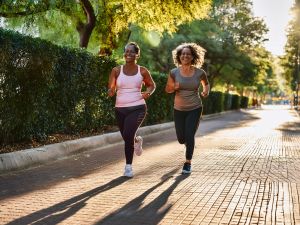 Two-women-walking Two women enjoying a fast walk on a tree lined street