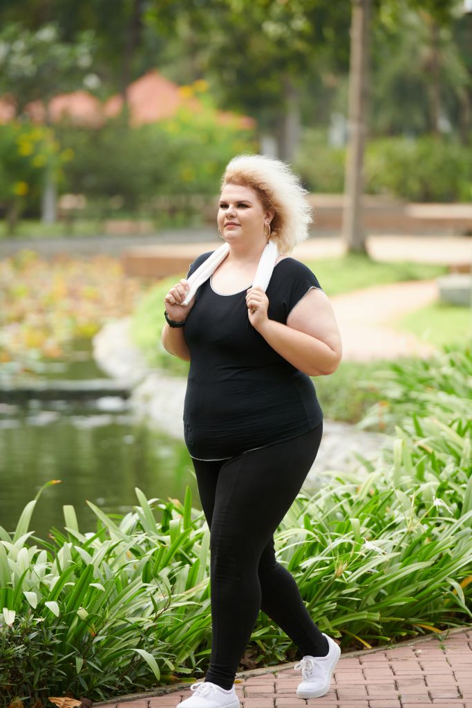 Woman on weight loss journey walking in a park
