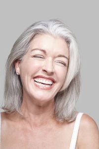 San Raphael,United States,Attractive mature Caucasian woman with silver grey hair in a white tank top, bare shoulders.