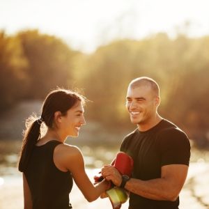 Athlete couple working out outdoors at sunset.