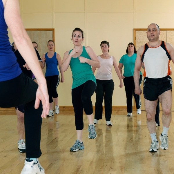 Group of men and women doing aerobic exercise at a gym Group of men and women doing aerobic exercise at a gym