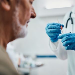 Close up of healthcare worker doing PCR test on a patient at medical clinic.